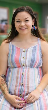 A smiling young woman kneeling.