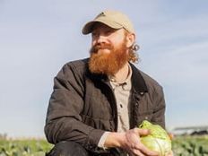 Farmer Mike holds a cabbage.