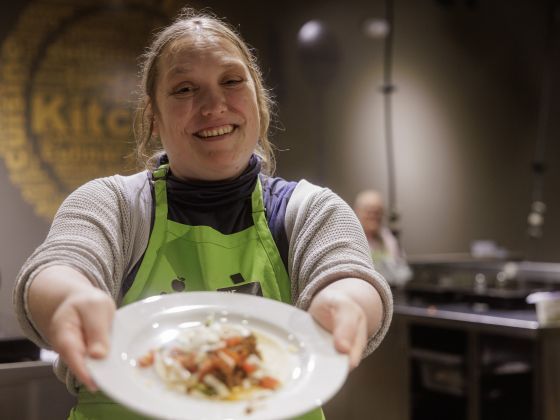 Kaycee holds a plate of food for the camera