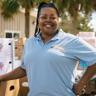 Woman standing in front of boxes of food.